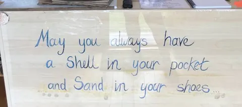 A sign with blue writing on it.