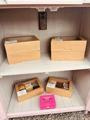 A pink box with a face on it is sitting on a shelf.