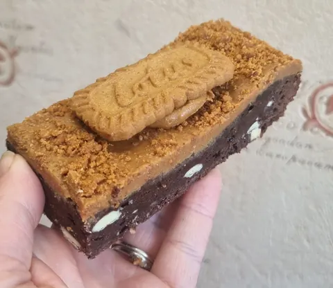 A piece of chocolate cake with a cookie on top.