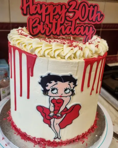 A birthday cake with a red frosting and a red dress on it.