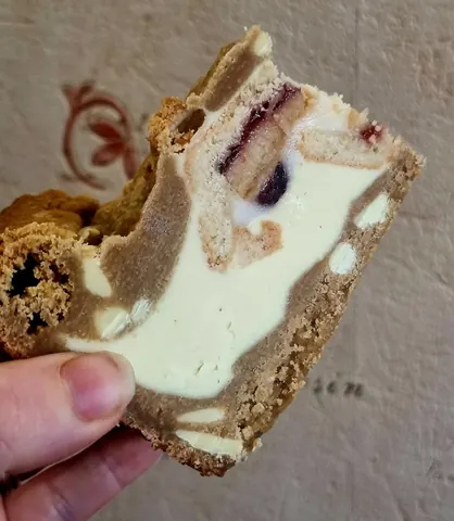 A person is holding a piece of cake.
