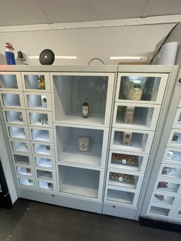 A refrigerator with a bottle of wine on the top shelf.
