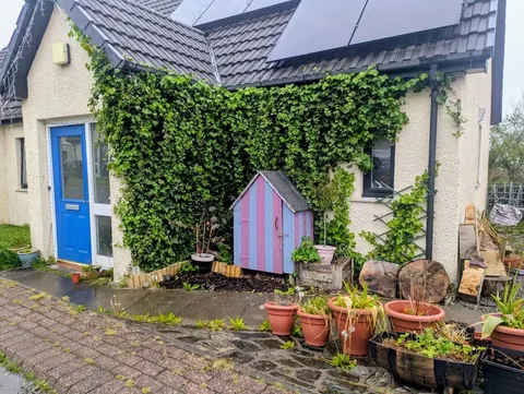 A house with a pink shed and a blue door.