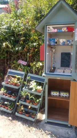 A small green shed with a sign that says "Open" on it.