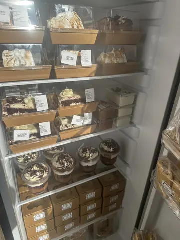 A refrigerator with a variety of desserts inside.
