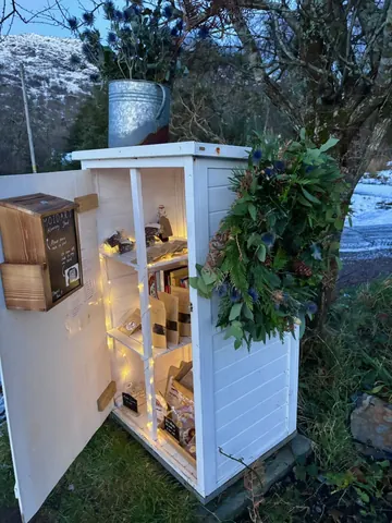 A small white building with a potted plant on the side.