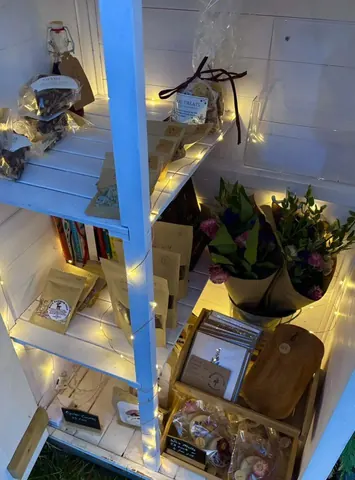 A shelf with a bunch of books and flowers on it.
