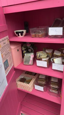 A pink shelf with a calculator on it.