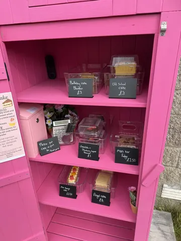 A pink cabinet with a sign that says "birthday cake".