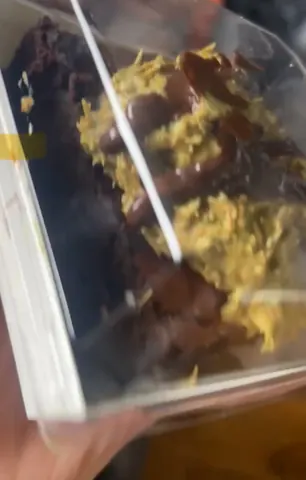 A bowl of food with a white spoon in it.
