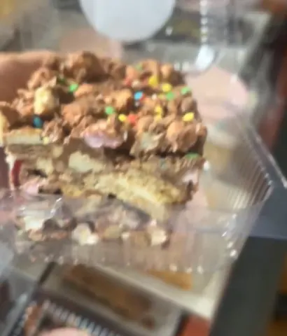 A piece of cake with sprinkles in a plastic container.