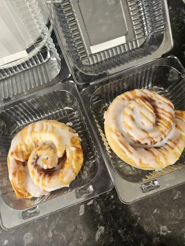 Two donuts in plastic containers.