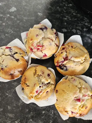 A table with a bunch of muffins on it.