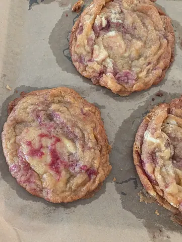 A tray of cookies with pink frosting.