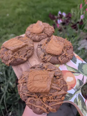 A wooden cutting board with a cookie on it.