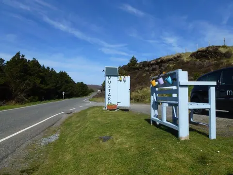 A white fence with a sign on it.
