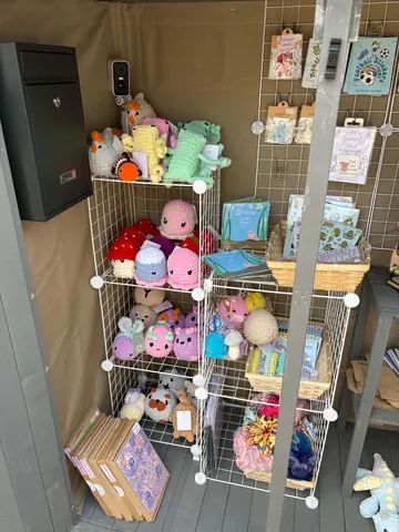 A shelf full of stuffed animals and books.