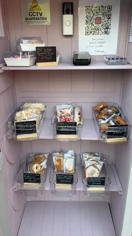 A display case with a variety of desserts in plastic containers.