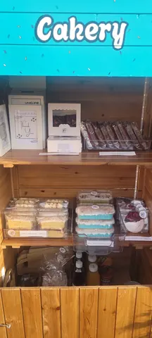 A display of cakes and pastries in a wooden case.