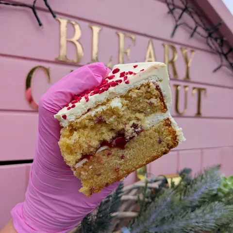 A person is holding a slice of cake.