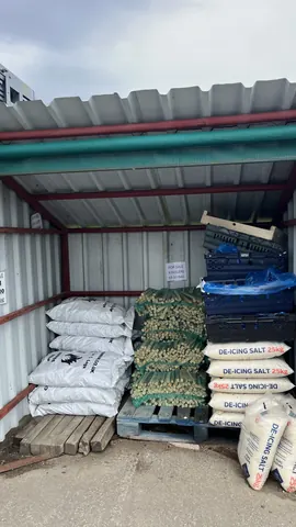 A large pile of bags and boxes are stacked in a storage area.