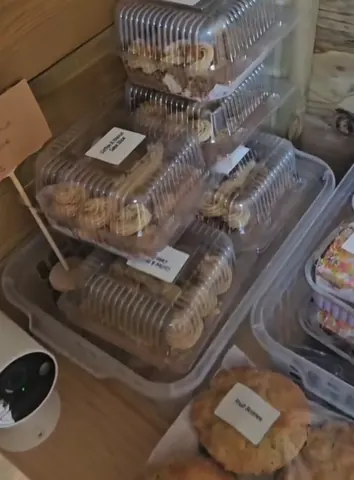 A stack of plastic containers filled with various types of pastries.