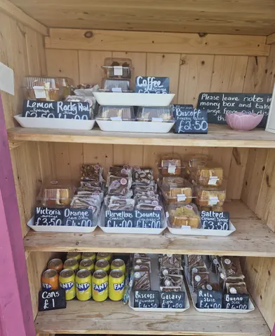 A wooden shelf with various food items and drinks on it.