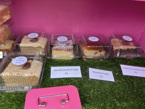 A pink box with a sign that says "jam & coconut cake" on it.
