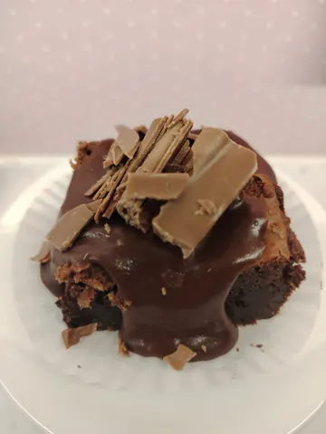 A chocolate cake with chocolate drizzle and chocolate chips on top.