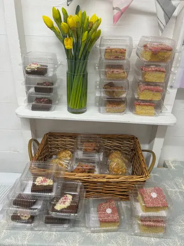 A basket of pastries with a vase of flowers in the middle.