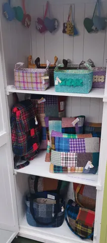 A shelf with various bags and a backpack on it.