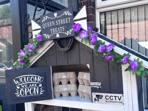 A sign that says Welcome to Queen Street Treats.