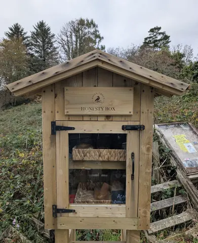 A wooden structure with a sign that says Honesty Box.