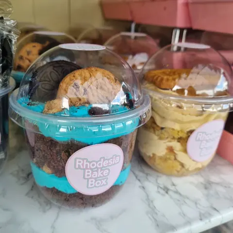 A display of various desserts in plastic containers.