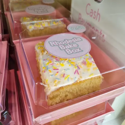 A box of cake with a pink background.