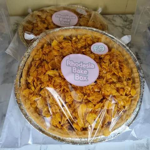 A pie with a pink label that says Rhodesia Bakery Box.