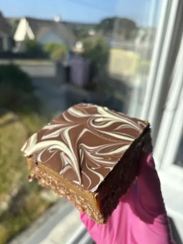 A person is holding a piece of cake.