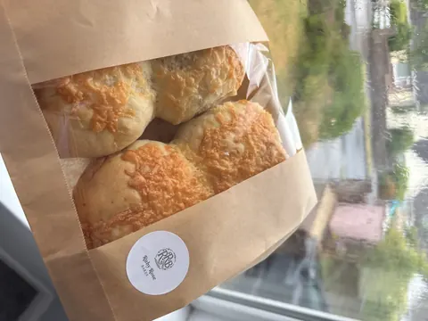 A bag of bread is sitting on a window sill.