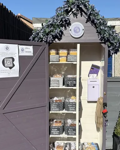 A purple shed with a white sign on it.