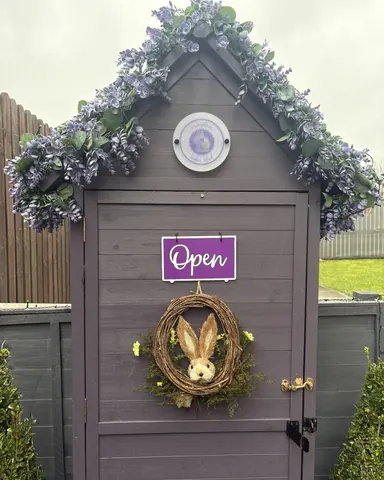 A purple shed with a sign that says open.