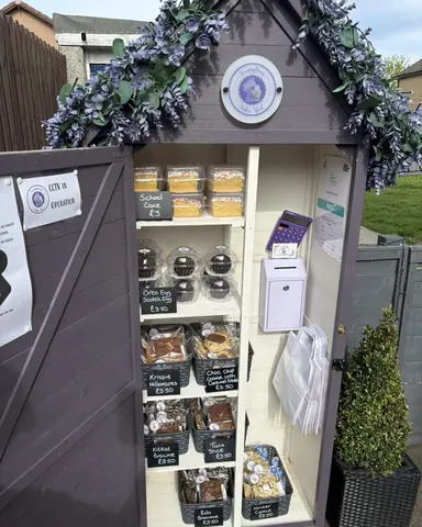 A small purple building with a sign that says "Coffee and Cake".