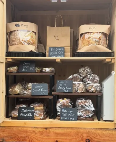 A wooden shelf with bags of food on it.