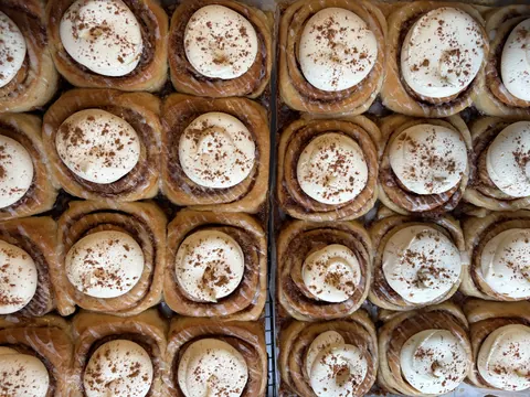 A tray of pastries with white frosting and brown sugar.