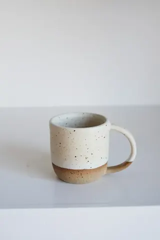 A white coffee mug with a brown handle.