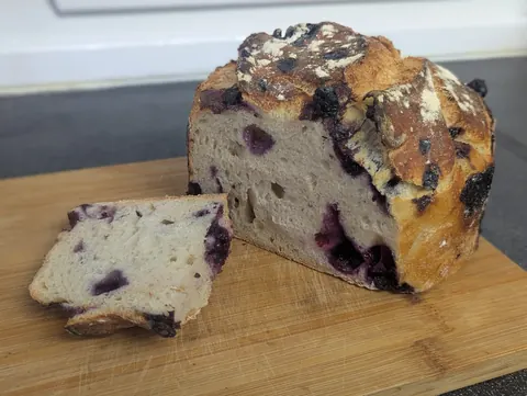 A loaf of bread with blueberries on top.