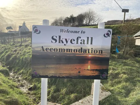 A sign welcoming visitors to Skyfall Accommodation.