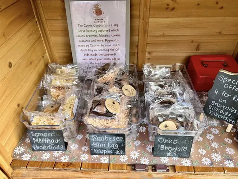 A wooden table with a sign that says "The Coffee Cupboard".