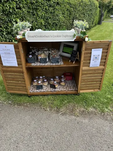 A wooden structure with a sign that says "smart cookie sam's cookie cupcake".