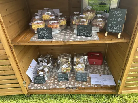 A wooden display case with a variety of pastries and desserts.