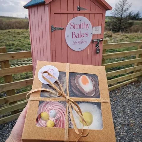 A box of pastries is being held by a person.